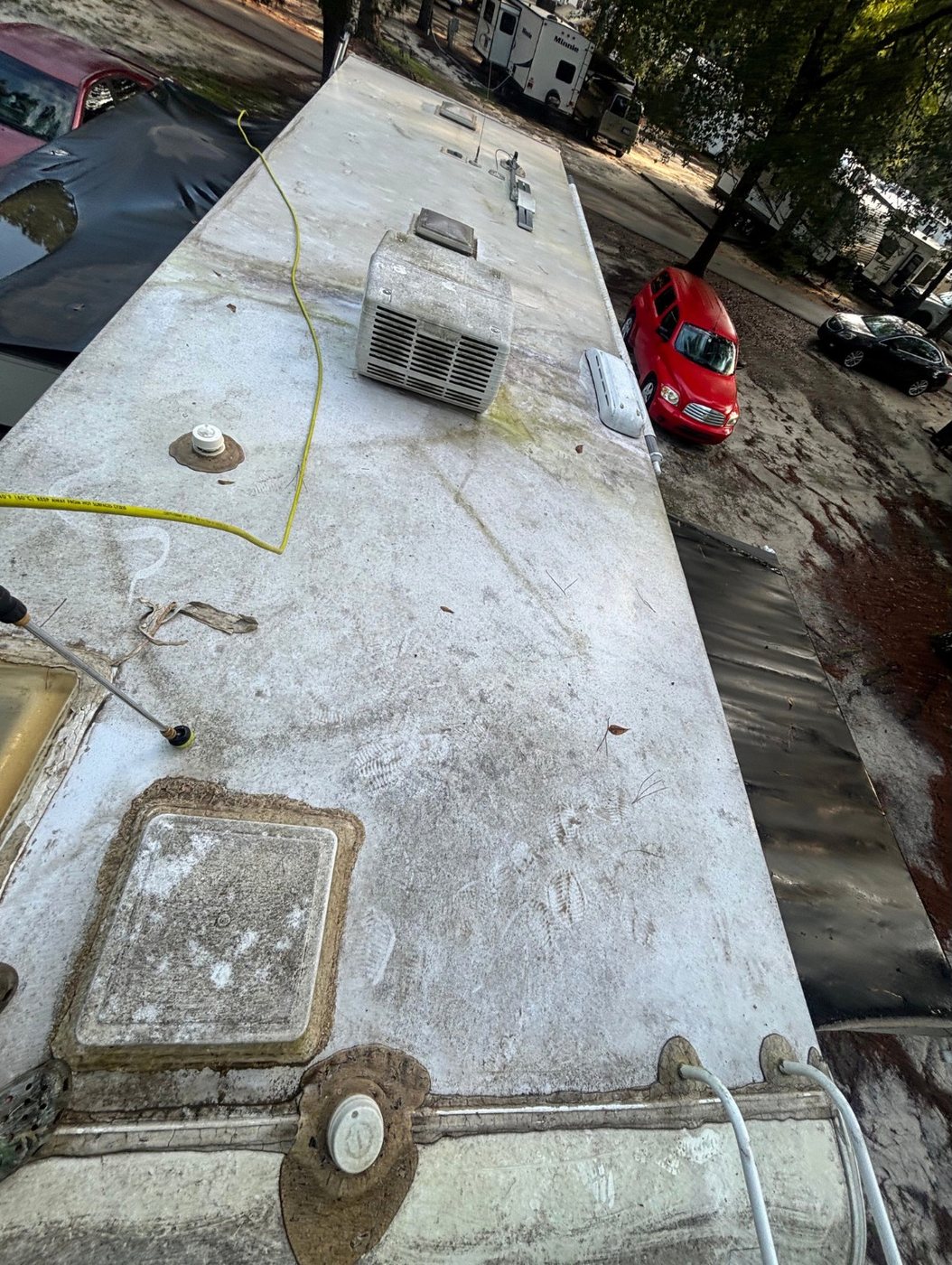 RV roof being pressure washed at a campground before coating