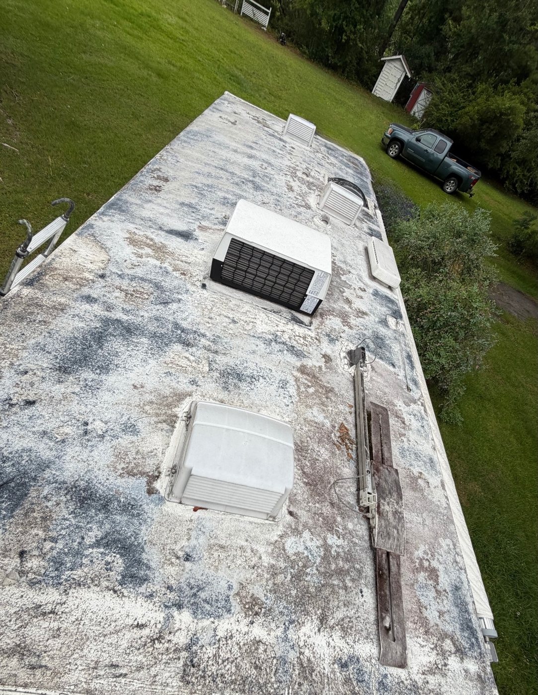 Stained RV roof with worn sealant around vents